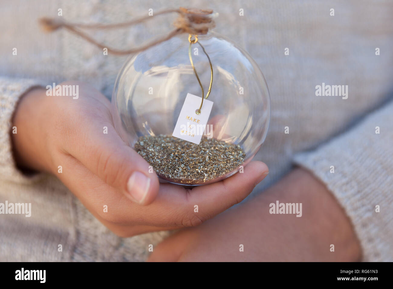 Jeune fille tenant une boule en verre avec un message make a wish Banque D'Images