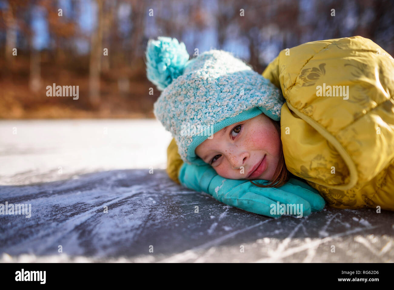 Portrait of a smiling girl couchée sur un étang gelé, United States Banque D'Images