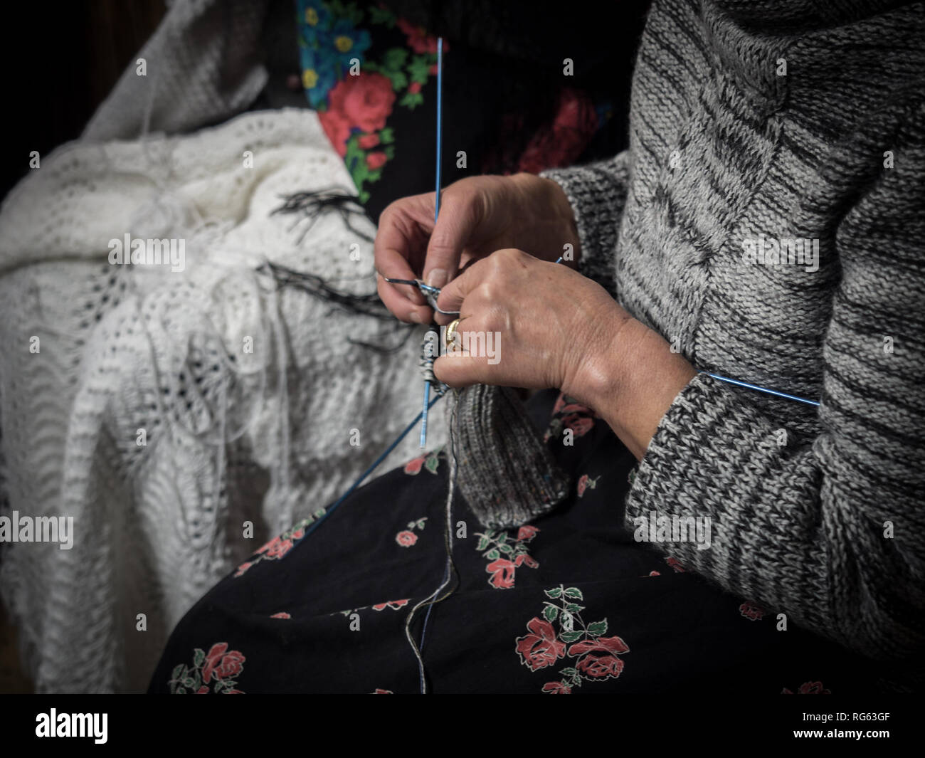 Détail d'une vieille dame tricotant une couverture de laine. Banque D'Images