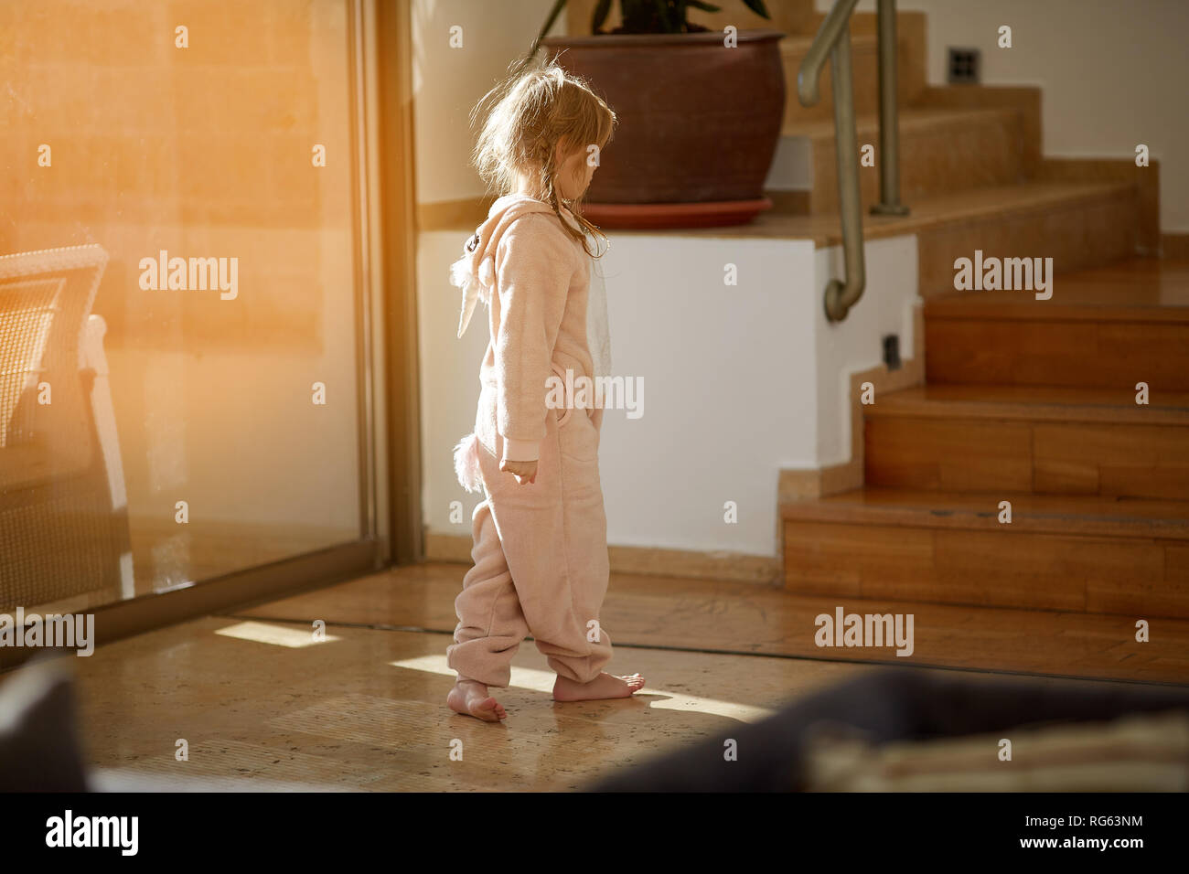 La colère jeune fille se tient sur le sol près de la fenêtre Banque D'Images