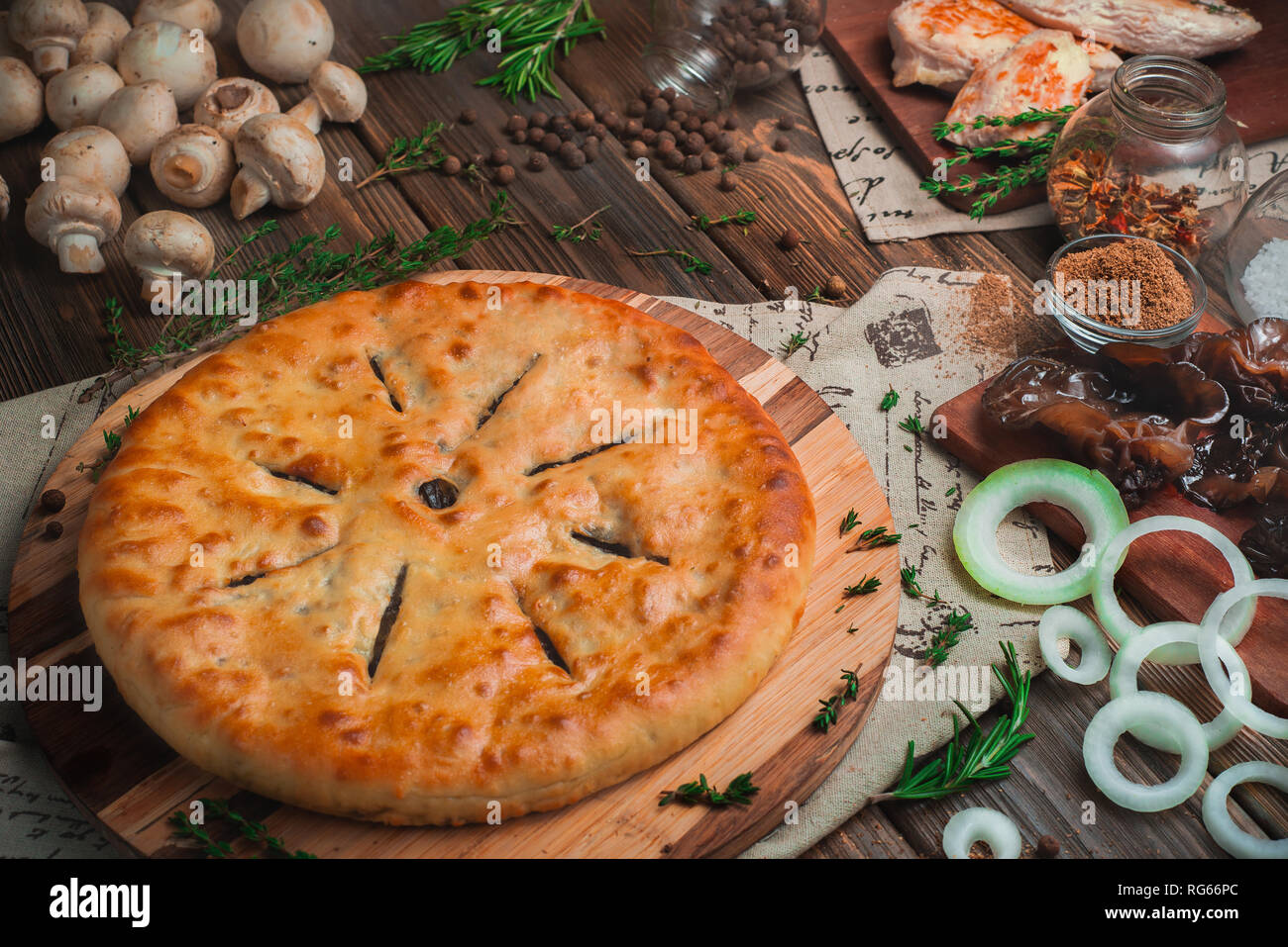 Des pâtés à la viande de poulet et les champignons sur un fond de bois avec des ingrédients. Concept de cuisine traditionnel avec des couleurs chaudes Banque D'Images