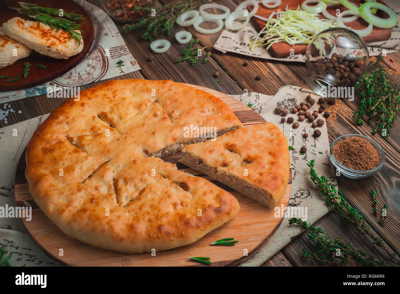 Tourte à la viande fait maison avec du poulet, les oignons et le chou. Concept de cuisson traditionnelle, couleurs chaudes, table de cuisine en bois avec des ingrédients Banque D'Images