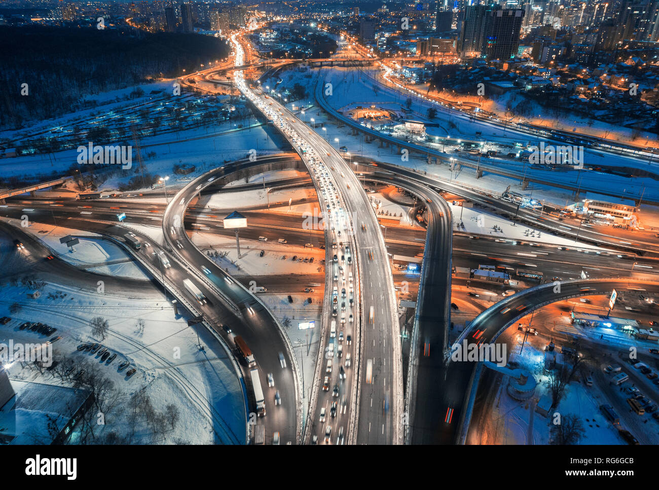 Vue aérienne de route dans la ville moderne la nuit en hiver. Vue de dessus de la circulation dans l'autoroute, les bâtiments, l'éclairage. Au cours de l'échange et la route surélevée Banque D'Images