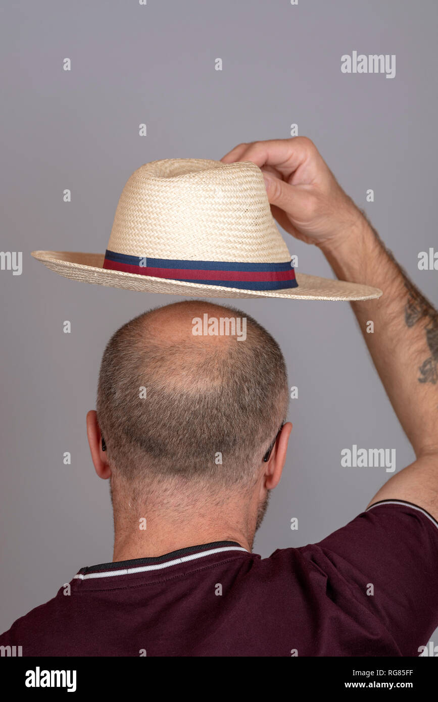 Homme chauve de mettre un chapeau de paille pour se protéger du soleil  Photo Stock - Alamy