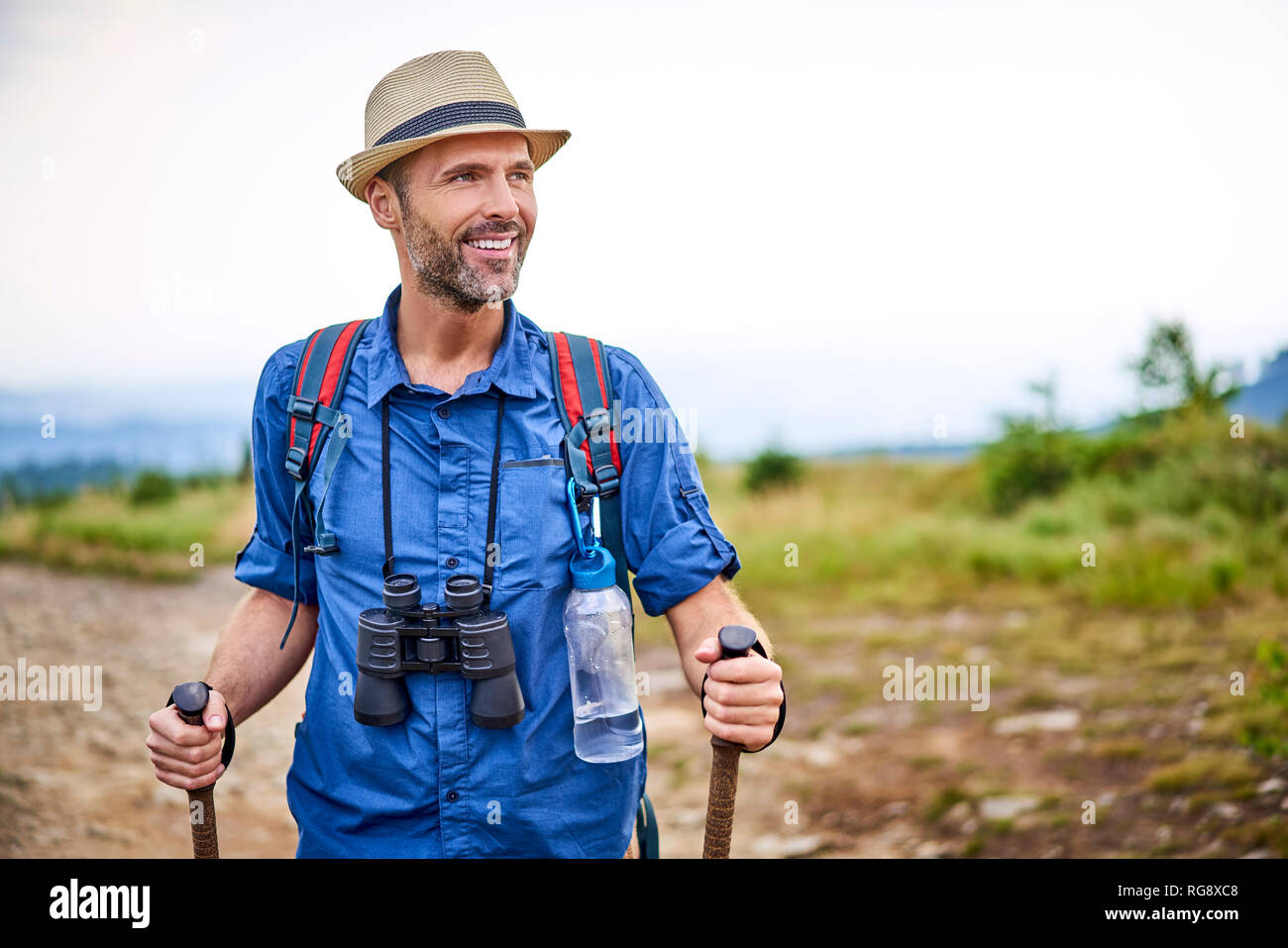 Smiling man with binoculars randonnée en montagne Banque D'Images