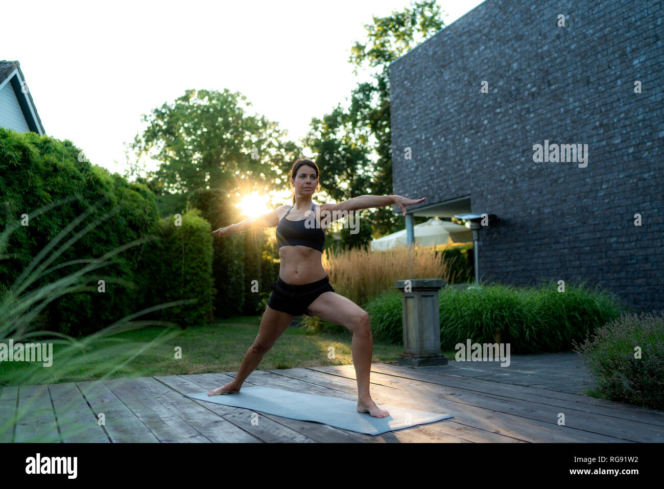 Woman practicing yoga in garden Banque D'Images Woman practicing yoga in garden Banque D'Images