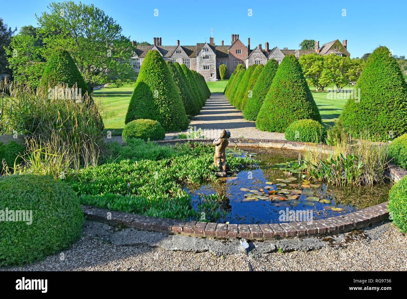 Topiaire élisabéthain jardin rural & chemin avec étang dans un parc historique et jardins des rangées de conifères répéter Littlecote House au-delà Wiltshire England UK Banque D'Images