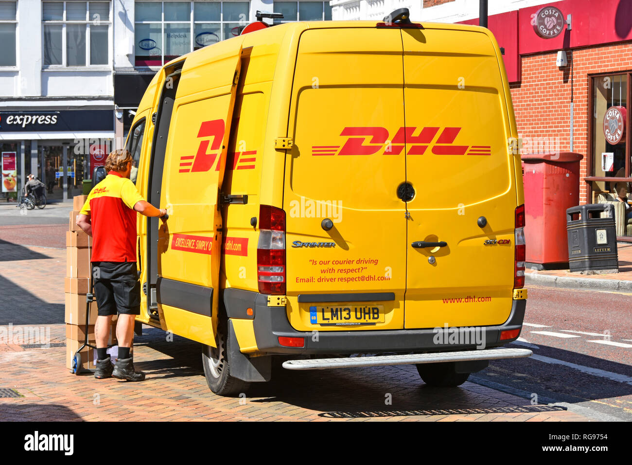 Vue arrière du pilote de distribution de colis homme en uniforme et de piles de boîtes de carton jaune sur chariot DHL Mercedes Benz Sprinter van dans Romford East London UK Banque D'Images