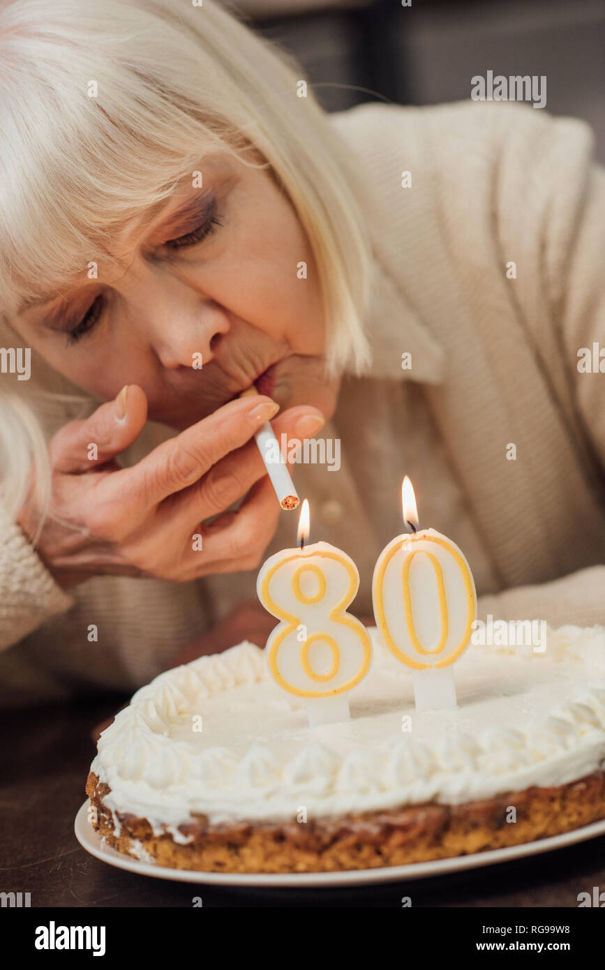 Close Up View Of Senior Woman Allumer Une Cigarette De Bruler Des Bougies Sur Le Gateau D Anniversaire A La Maison Photo Stock Alamy