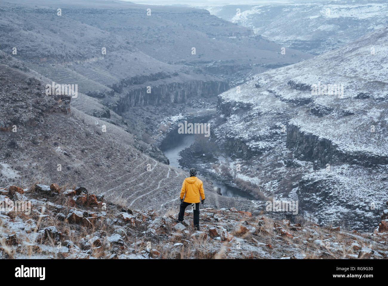 Randonneur avec manteau jaune debout au sommet d'une montagne et profiter Banque D'Images