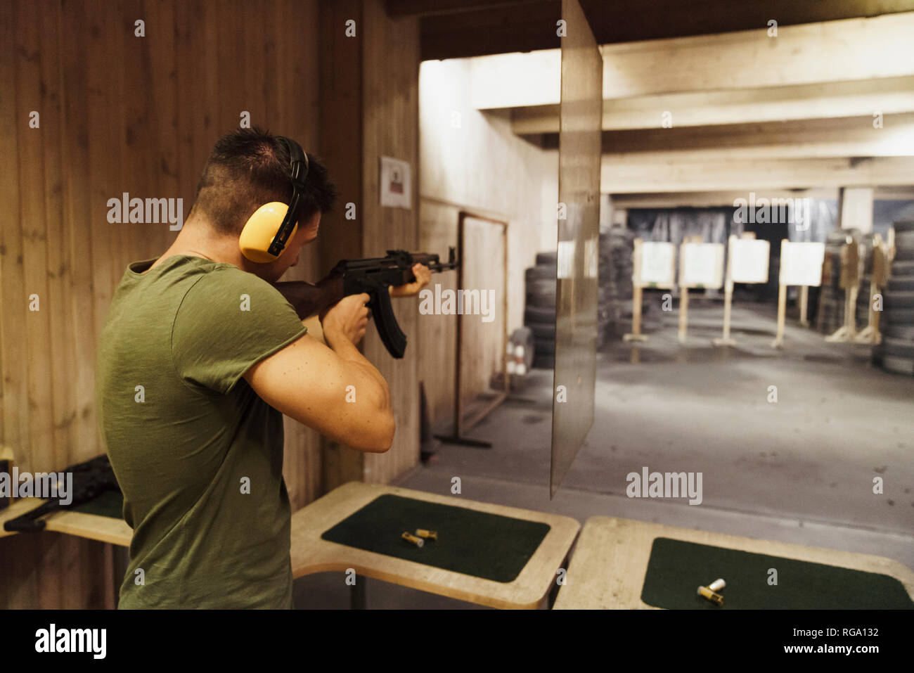 L'homme en vue d'un fusil dans un intérieur de tir Banque D'Images