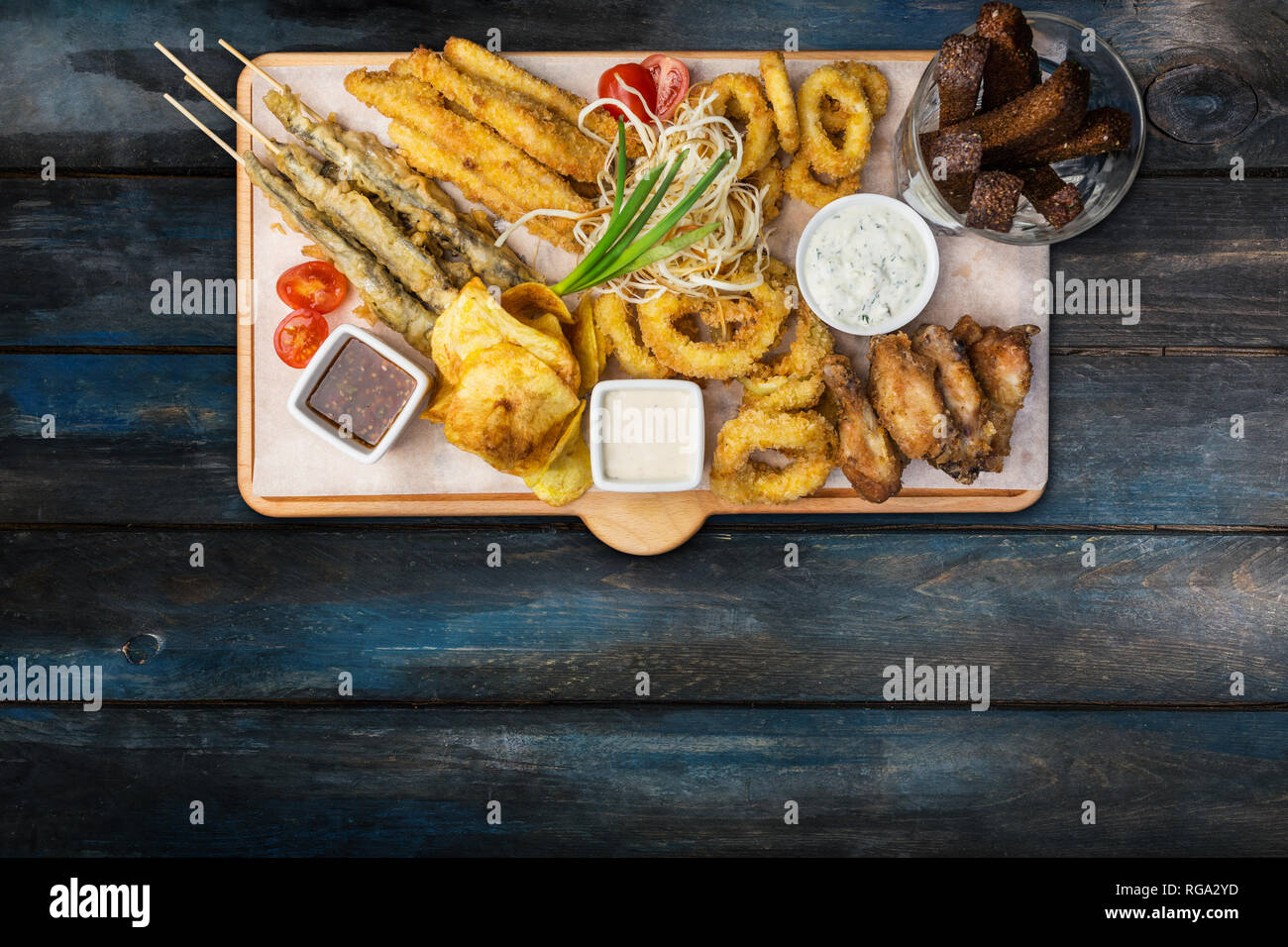 En-cas de la bière. Jeu de poisson servi sur planche à découper, tasses, sur le fond de bois. Banque D'Images