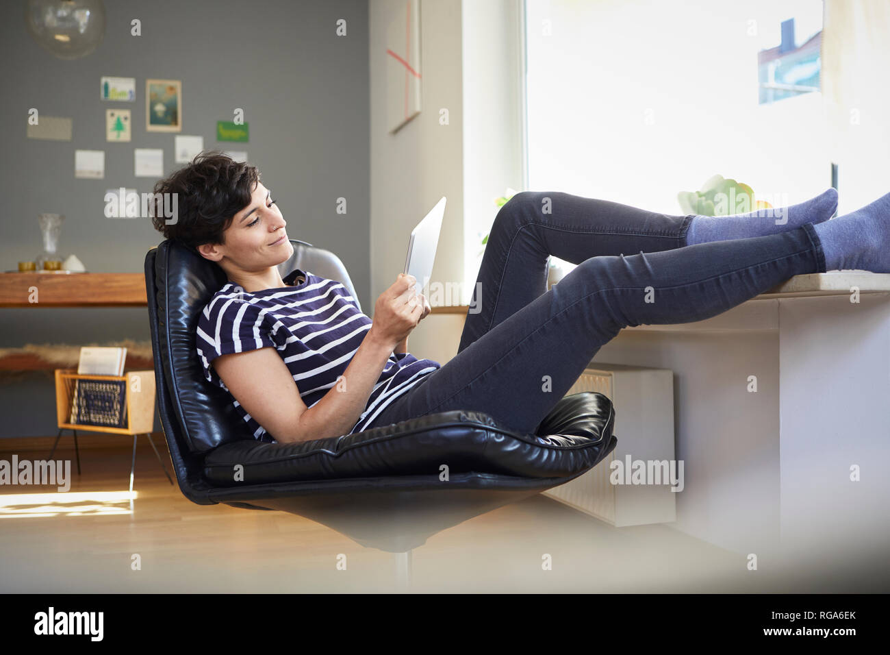 Relaxed woman using tablet at home Banque D'Images
