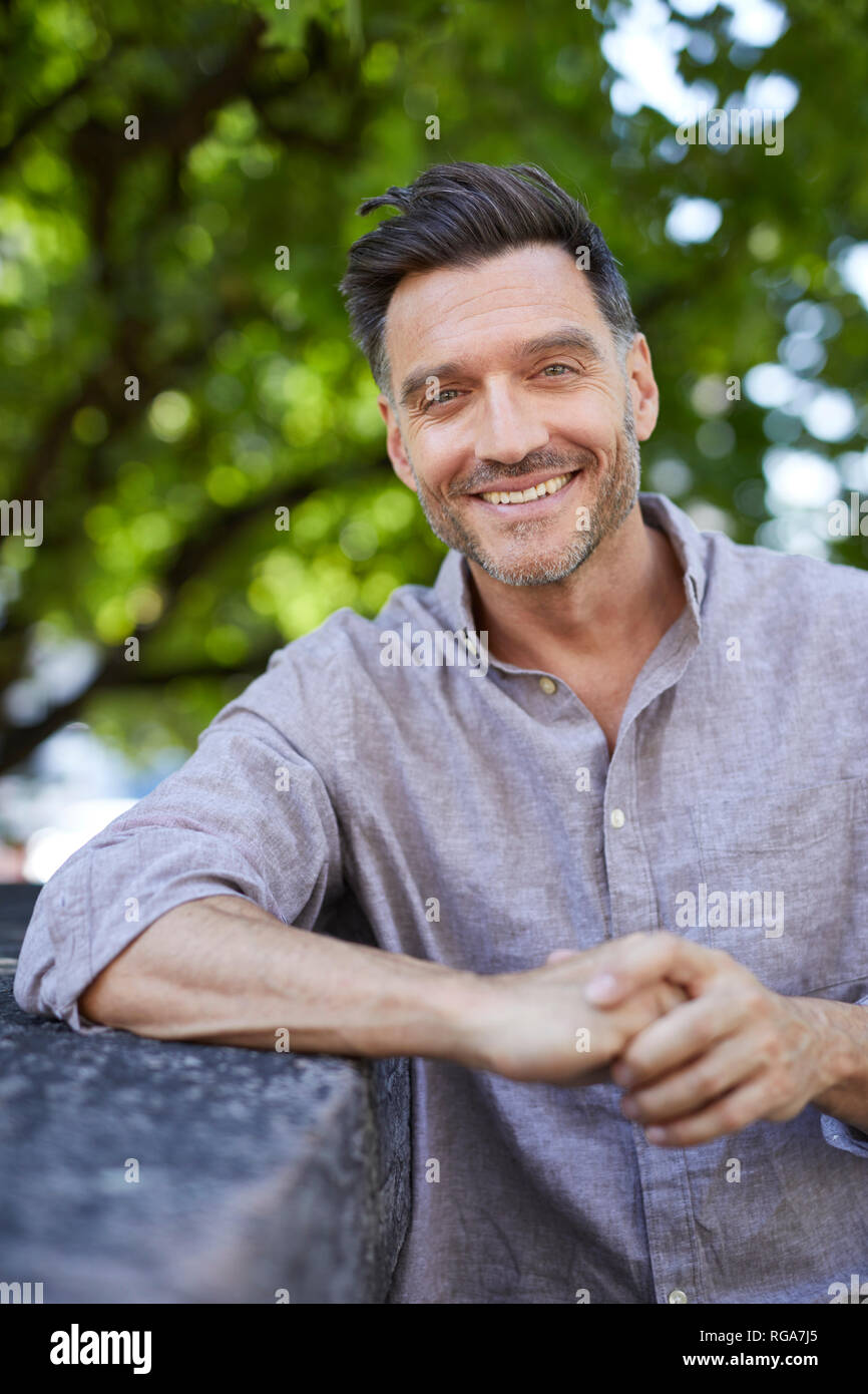 Portrait of laughing man leaning on a wall Banque D'Images