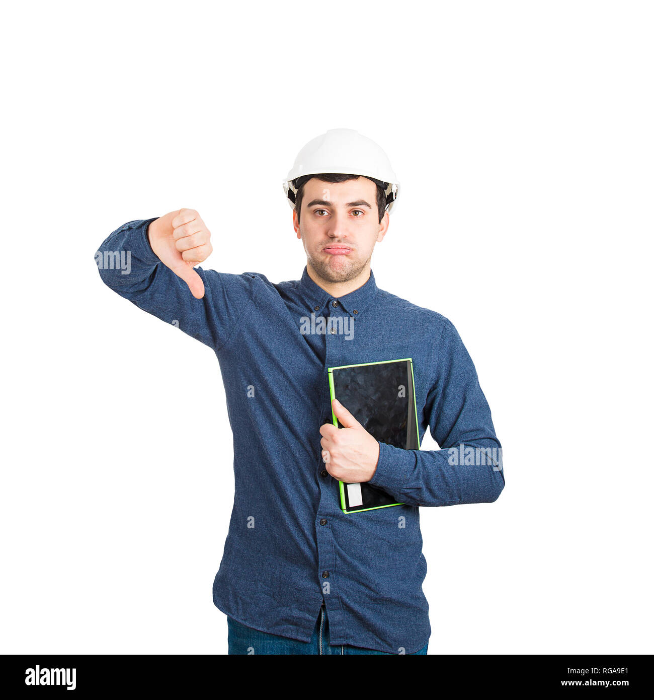 Fatigué et malheureux jeune homme portant des ingénieur helmet holding tablet showing thumb down geste rétroaction négative à ennuyer à c Banque D'Images