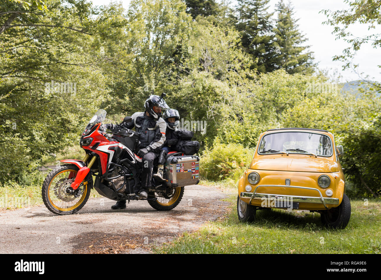Père et fils sur une moto voyage sur une route de campagne l'arrêt à côté d'une  voiture compacte Photo Stock - Alamy