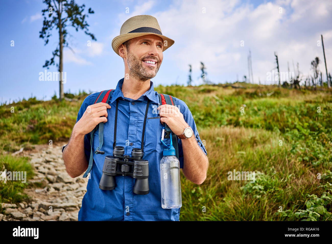 Smiling man with binoculars randonnée en montagne Banque D'Images