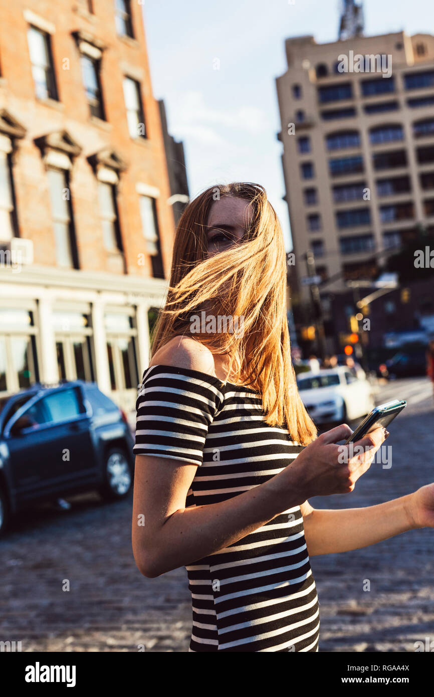 USA, New York, Brooklyn, Dumbo, woman with cell phone traversant la rue Banque D'Images