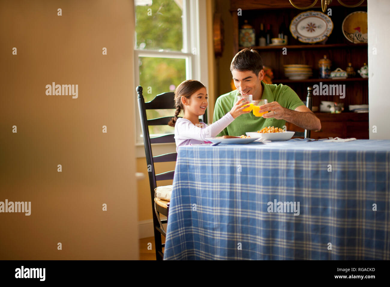 Père et fille manger ensemble lors d'une table à manger. Banque D'Images