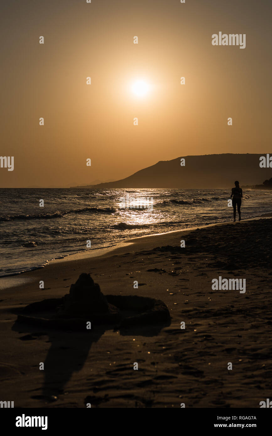 L'exercice à la glissière de lever de soleil sur la plage avec un château de sable Banque D'Images L'exercice à la glissière de lever de soleil sur la plage avec un château de sable Banque D'Images