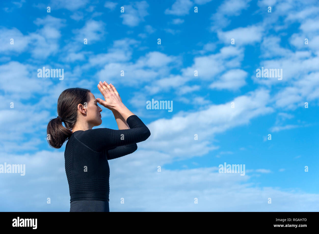 Femme spirituelle en yoga méditation troisième œil posent avec ciel bleu toile Banque D'Images