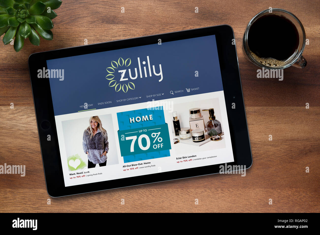 Le site internet de Zulily est vu sur un iPad tablet, sur une table en bois avec une machine à expresso et d'une plante (usage éditorial uniquement). Banque D'Images
