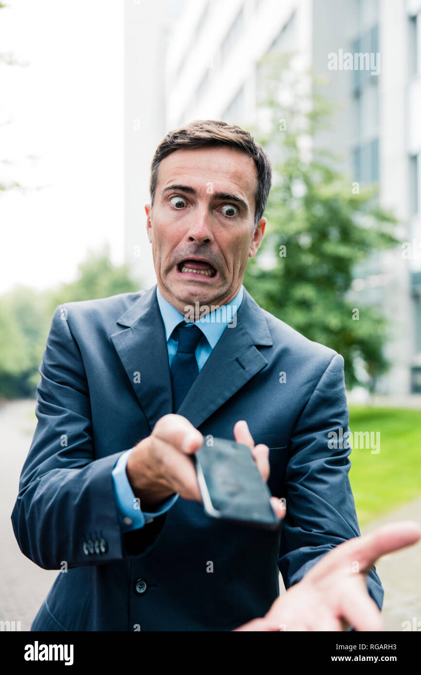 Choqué businessman with cell phone dans la ville Banque D'Images