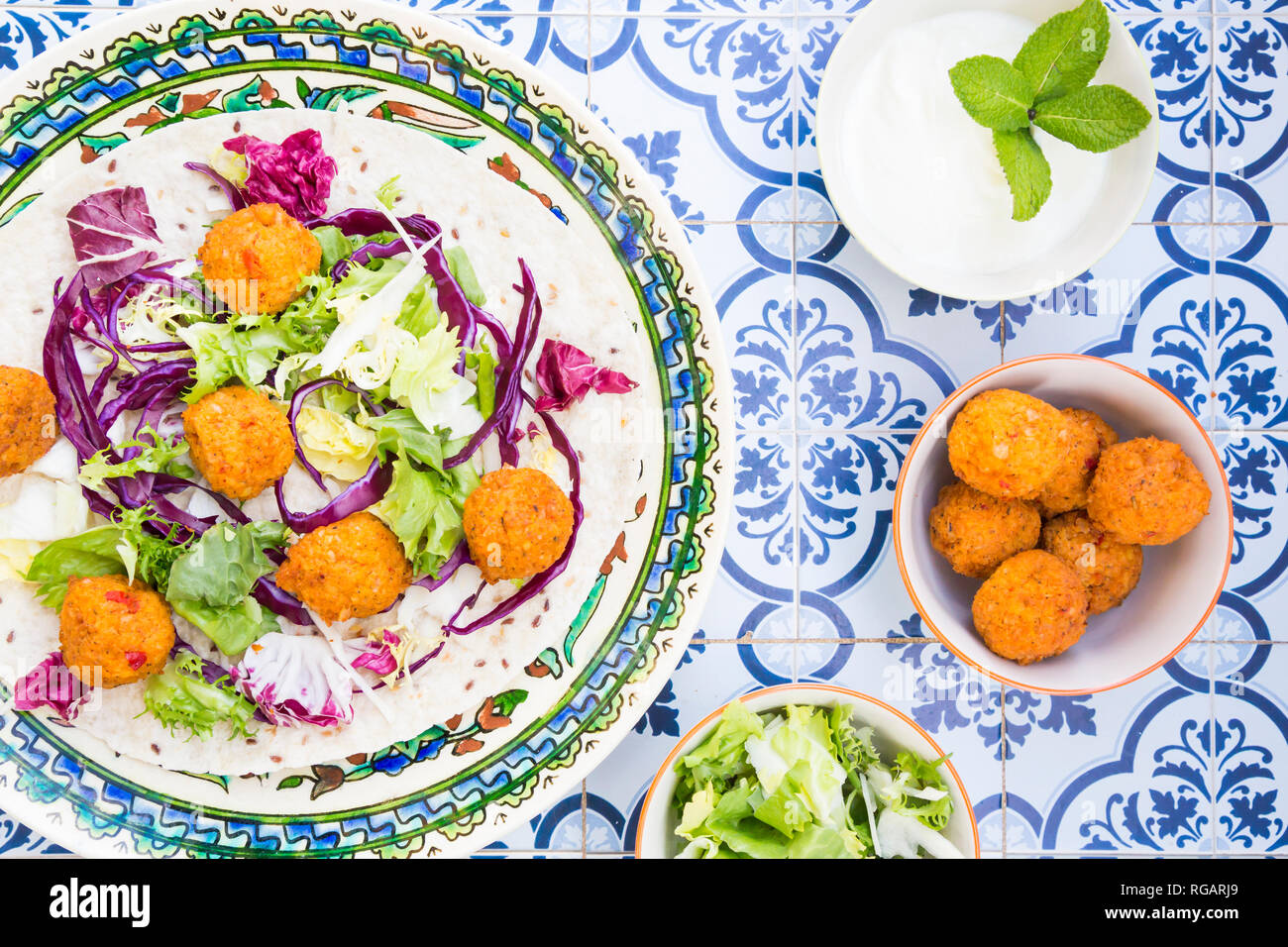 Falafel, feuille de salade, chou rouge et blanc et sauce yogourt à la menthe sur wrap Banque D'Images