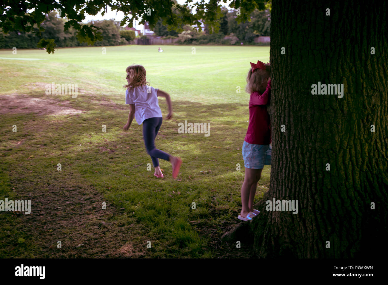 Deux jeunes filles joue à cache-cache dans un parc en été Banque D'Images