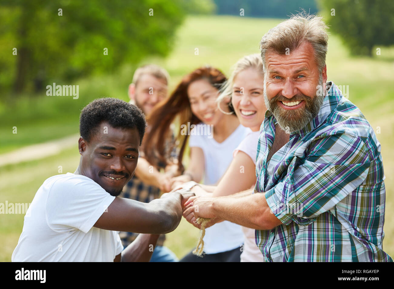L'équipe multiculturelle, remorqueur de la guerre à l'événement team building Banque D'Images