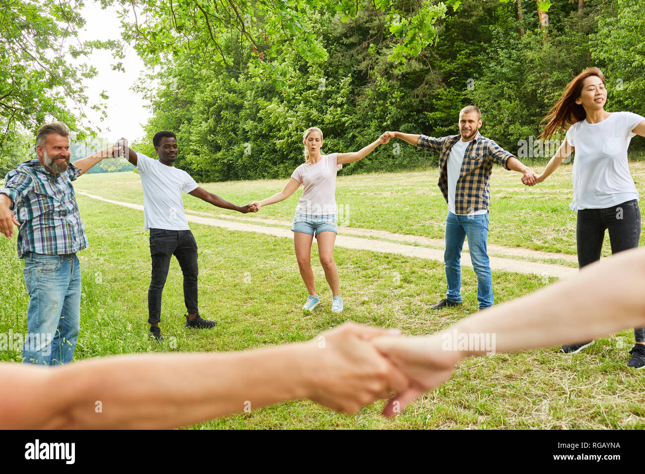 Les jeunes heureuse équipe forme un cercle dans le parc dans un atelier teambuilding Banque D'Images