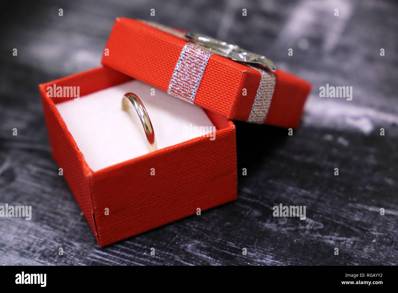 Boîte-cadeau avec anneau d'or sur la table en bois vintage. Concept de proposition de mariage, bijoux, cadeaux Saint Valentin, romantique présent Banque D'Images