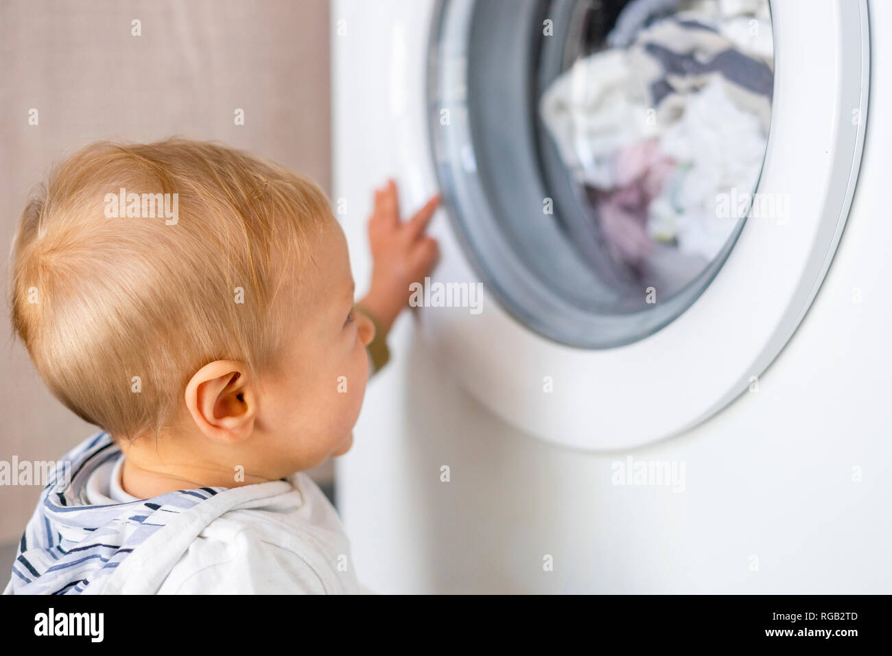Baby Boy intéressés par les cycles de machine à laver la lessive Banque D'Images