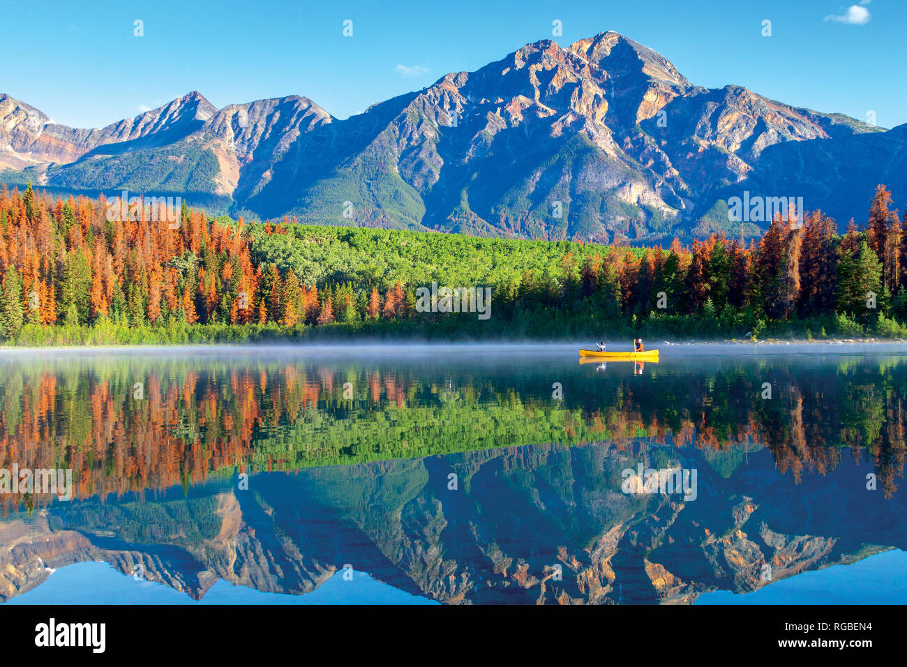 Nautisme sur Patricia Lake dans le Parc National Jasper avec Pyramid Mountain en arrière-plan et sereine des réflexions sur la surface de l'eau. Banque D'Images