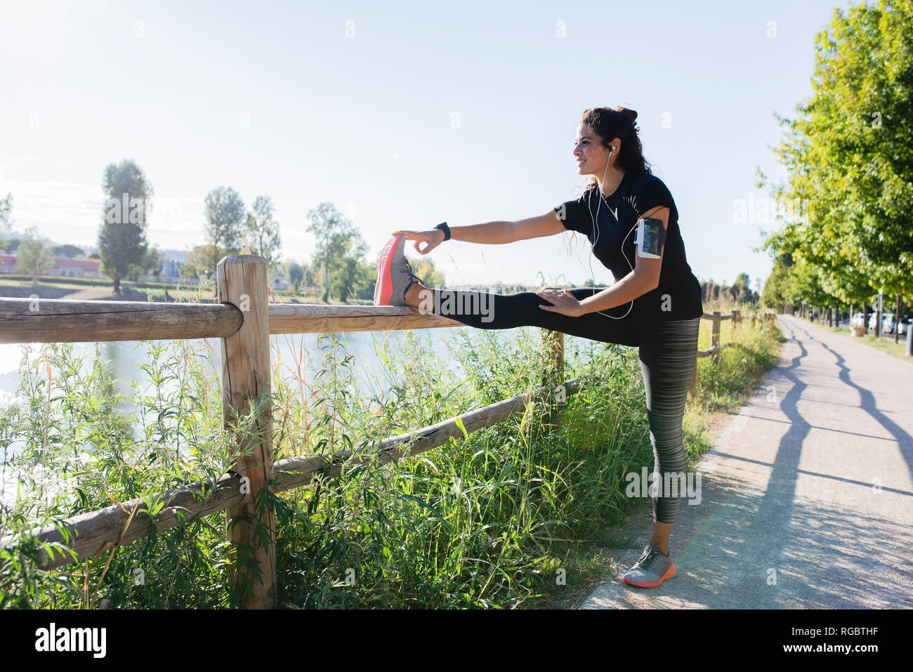 Jeune femme sportive étend sa jambe au Riverside Banque D'Images