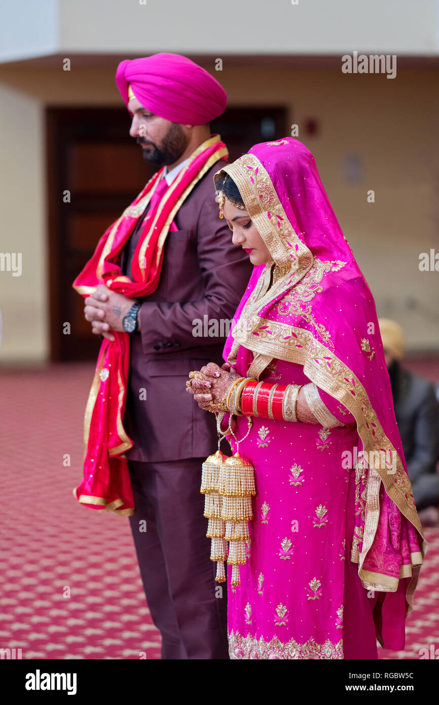 Une mariée et le marié pendant leur cérémonie de mariage dans un temple sikh à Queens, New York. Banque D'Images