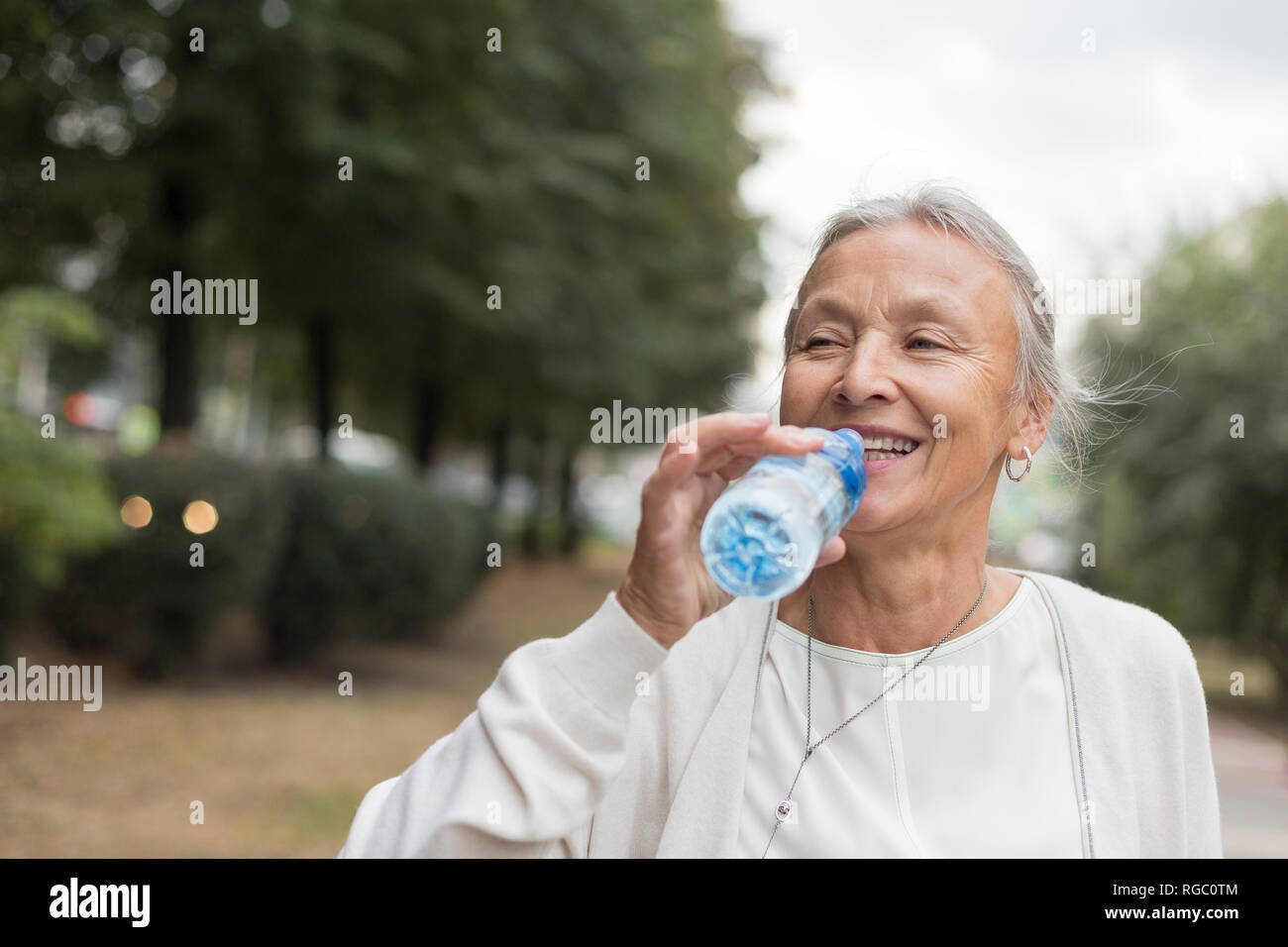 Happy senior woman outdoors bouteille de l'eau potable Banque D'Images