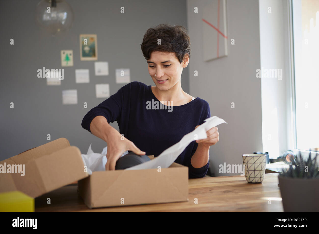 Smiling woman packing colis à la maison Banque D'Images