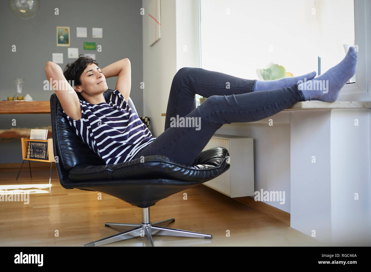 Smiling woman sitting at home relaxing Banque D'Images