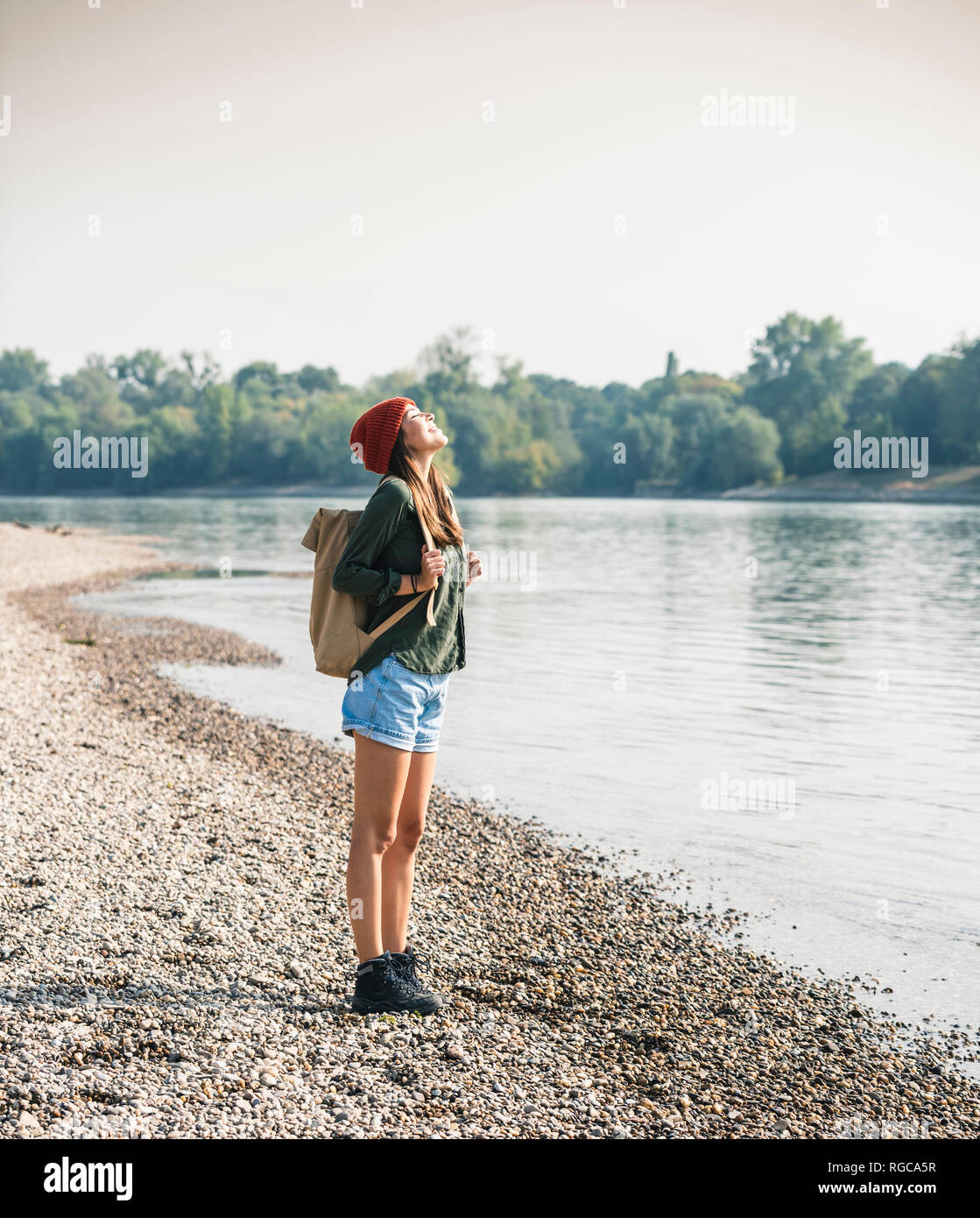 Happy young woman standing at the riverside Banque D'Images