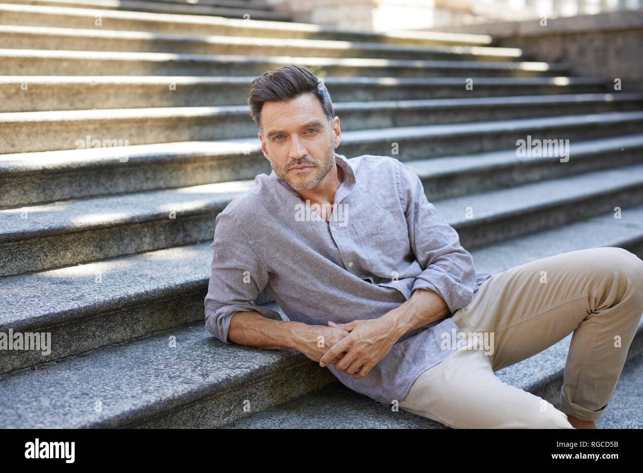 Portrait of serious mature man sitting on stairs Banque D'Images