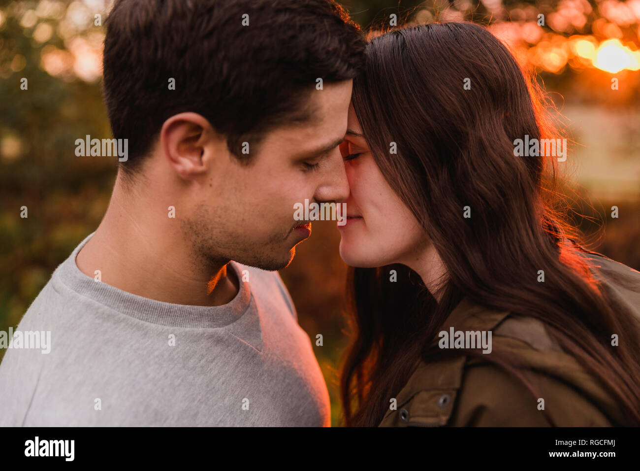 Couple heureux dans l'amour dans la nature au coucher du soleil d'automne Banque D'Images