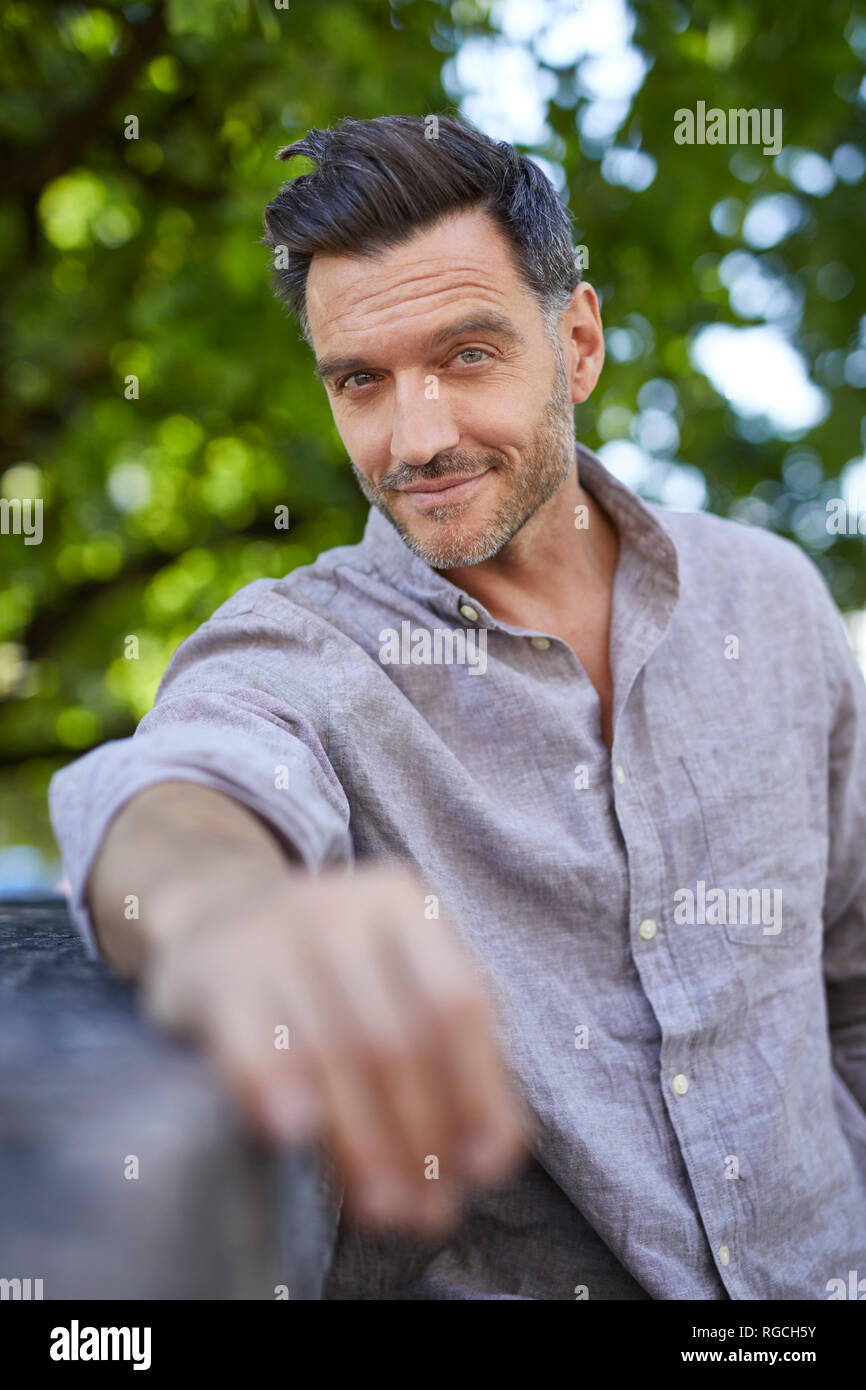 Portrait of smiling young man leaning on a wall Banque D'Images