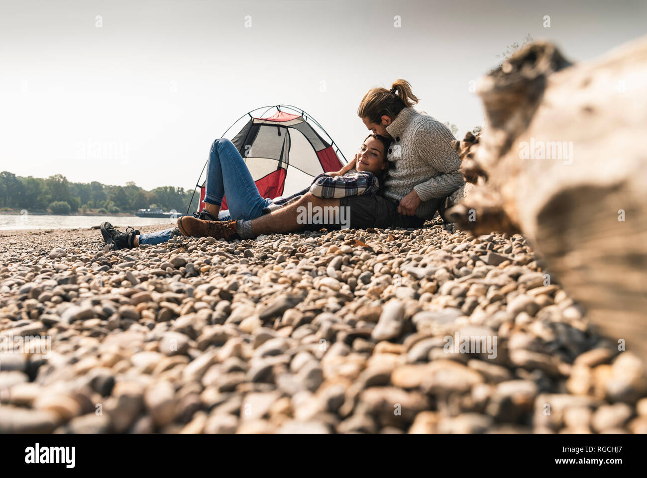 Happy young couple relaxing at une tente au bord du fleuve Banque D'Images