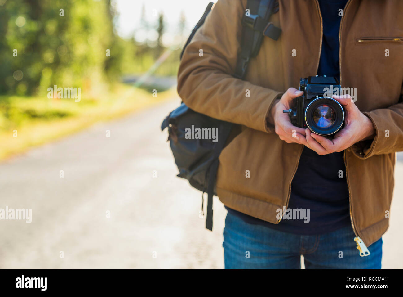 La Finlande, Laponie, close-up of man holding camera on country road Banque D'Images