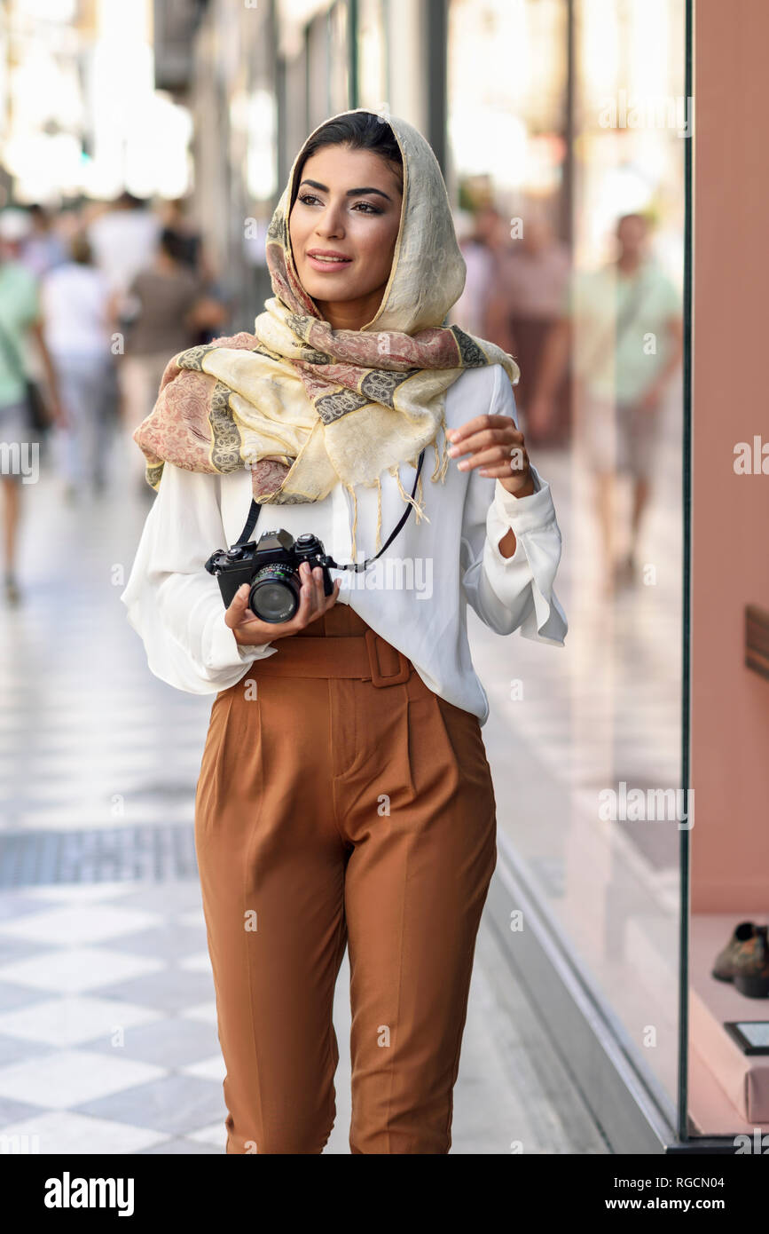 L'Espagne, Grenade, les jeunes touristes Arabes femme portant le hijab, en utilisant fotocamera lors du shopping dans la ville Banque D'Images