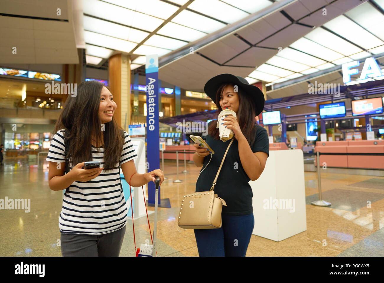 Singapour - circa 2016, août : les jeunes femmes à l'aéroport de Singapour Changi Terminal 2 hall de départ Banque D'Images