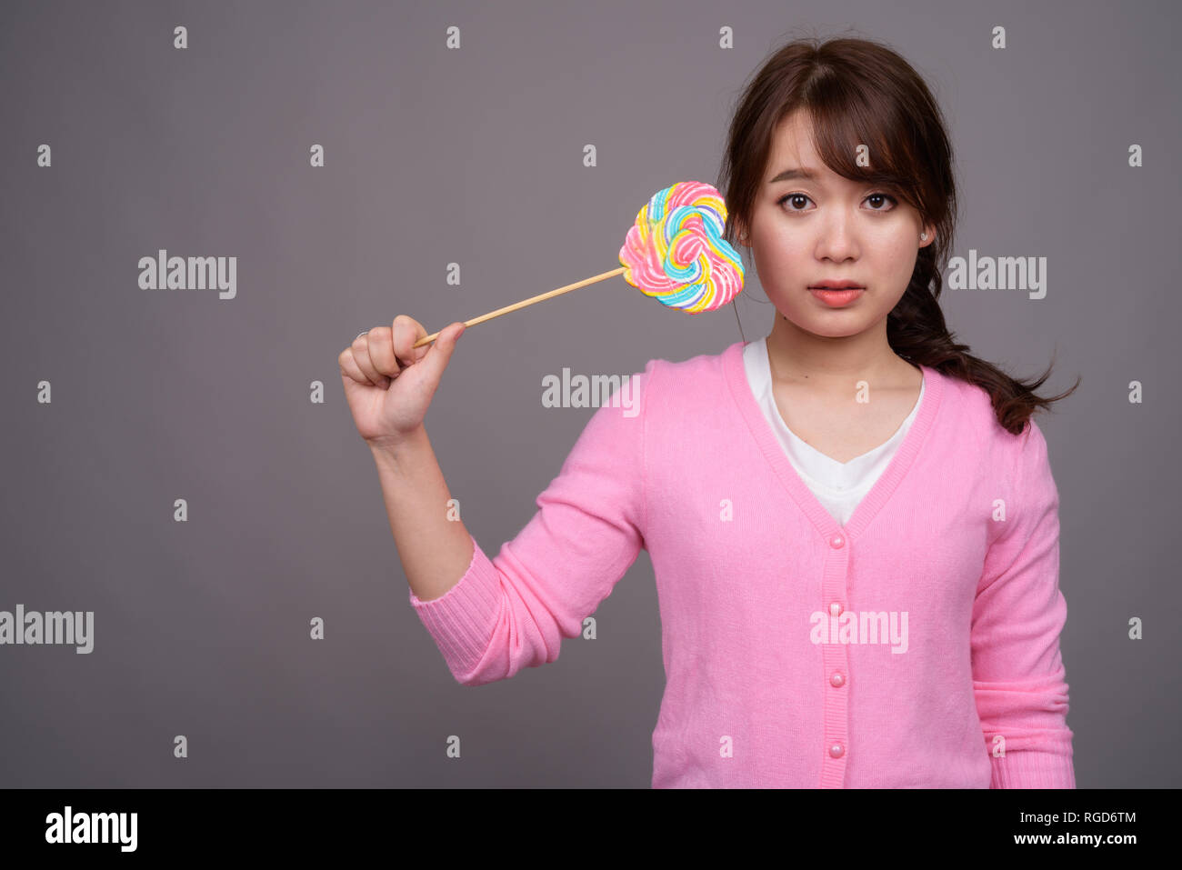 Jeune belle Asian woman holding colorful lollipop Banque D'Images