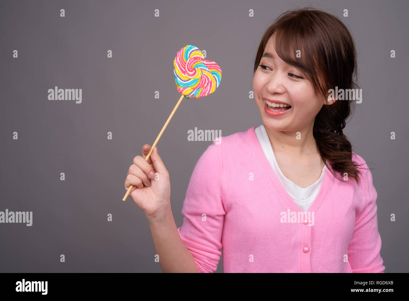 Jeune belle Asian woman holding colorful lollipop Banque D'Images