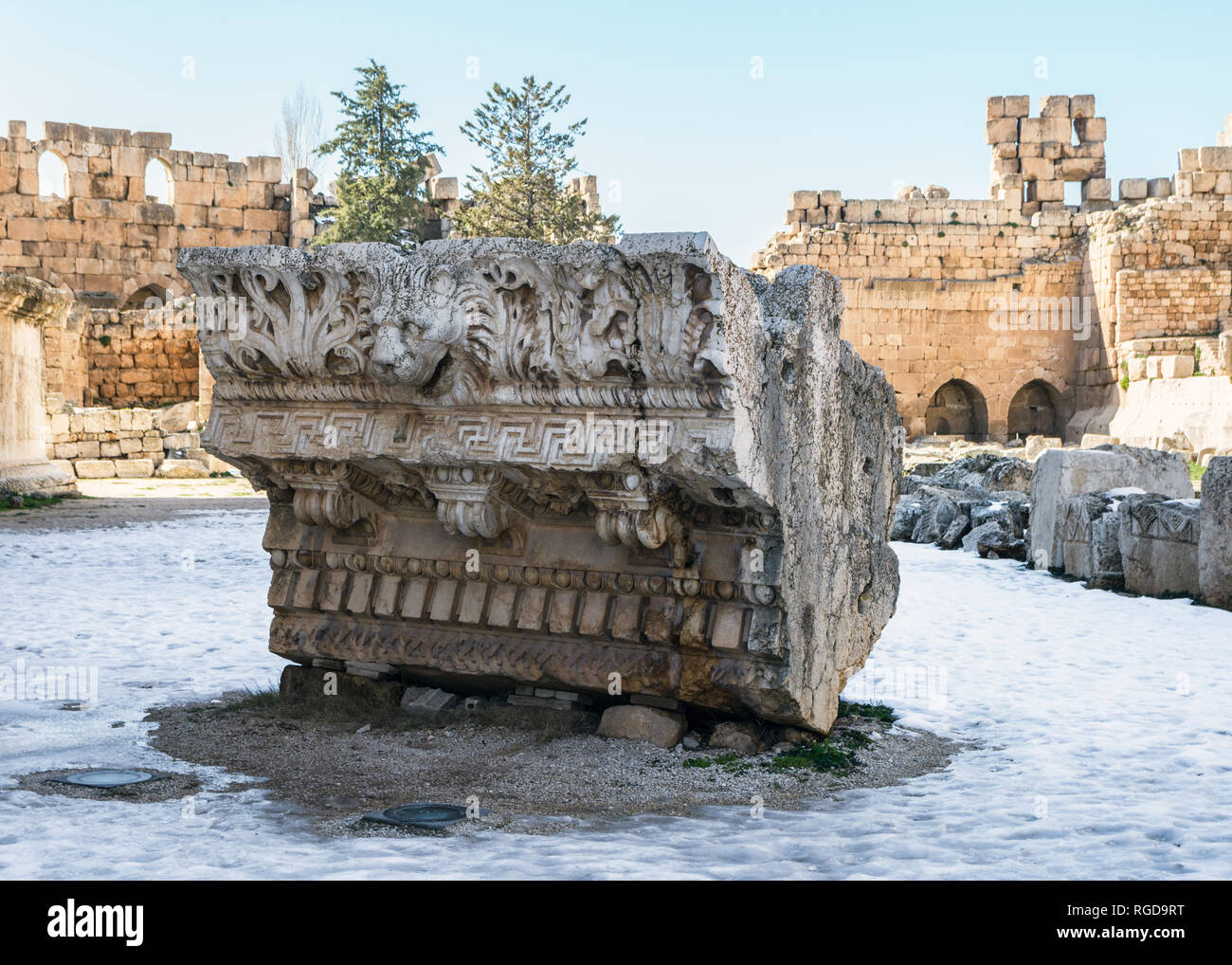 Corniche ornée d'une chute de la tête de lion gargouille sur sol couvert de neige, Héliopolis vestiges romains, de Baalbek, au Liban Banque D'Images